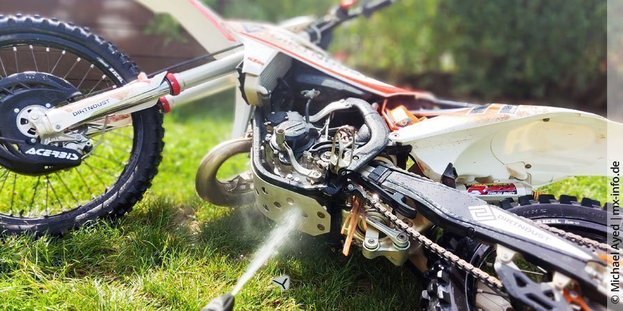Motocross waschen: Motorrad auf Seite legen und von unten reinigen